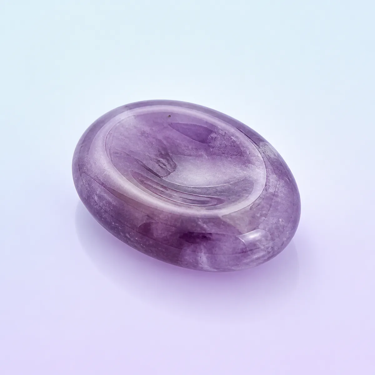 Calm Worry Stone: polished amethyst stone with a thumb hollow on a soft pastel background