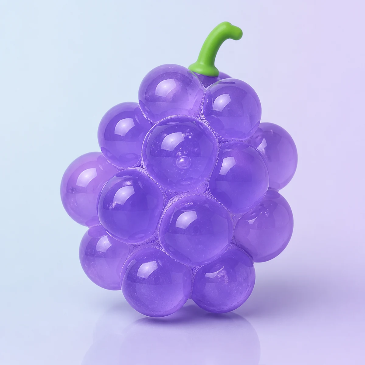 Bubble Grapes Squeeze Ball: translucent purple bubble cluster with a green stem on a soft pastel background