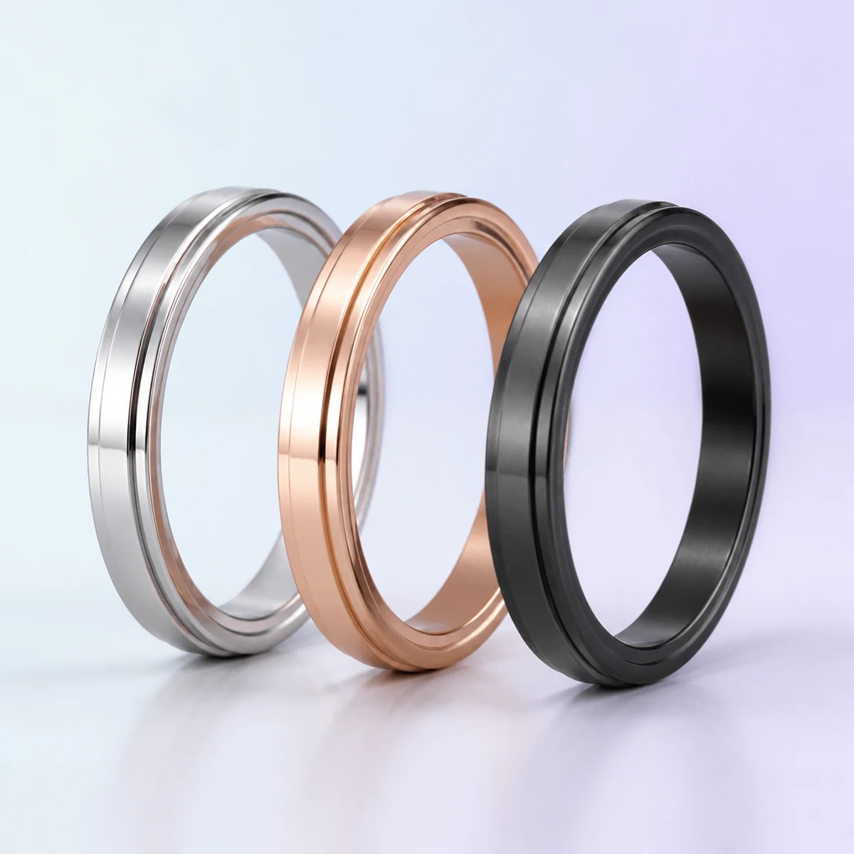 Quiet Spinner Sensory Ring Set: silver, rose-gold and matte-black spinner rings on a soft pastel background