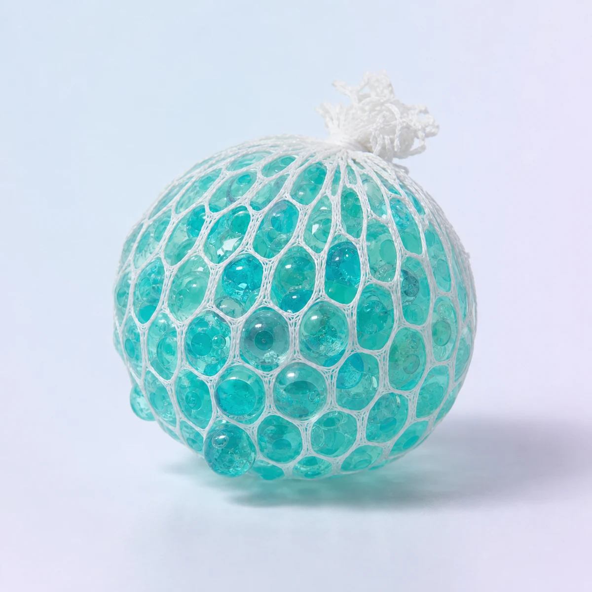 Calm Orb Water-Bead Squeeze Ball: aqua gel beads inside a white mesh ball on a soft pastel background